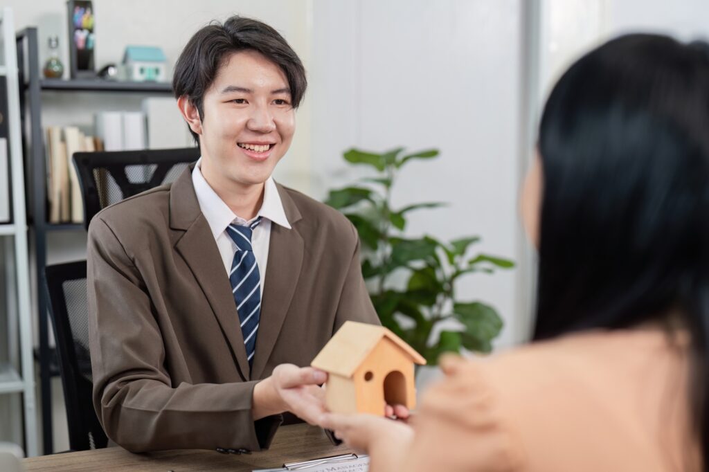 Real Estate Agent Facilitating Property Sale Discussion with Client for Home Ownership Goals